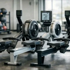 rameur-concept2-pm5-equipe-dun-moniteur-pm5-centre-deux Rameur Concept2 PM5 équipé d’un moniteur PM5 au centre, avec deux autres rameurs en arrière dans une salle de sport.