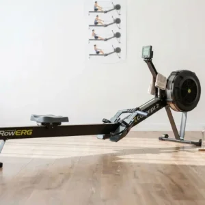 Rameur Concept2 RowERG posé sur un parquet clair dans une salle de sport épurée à domicile.